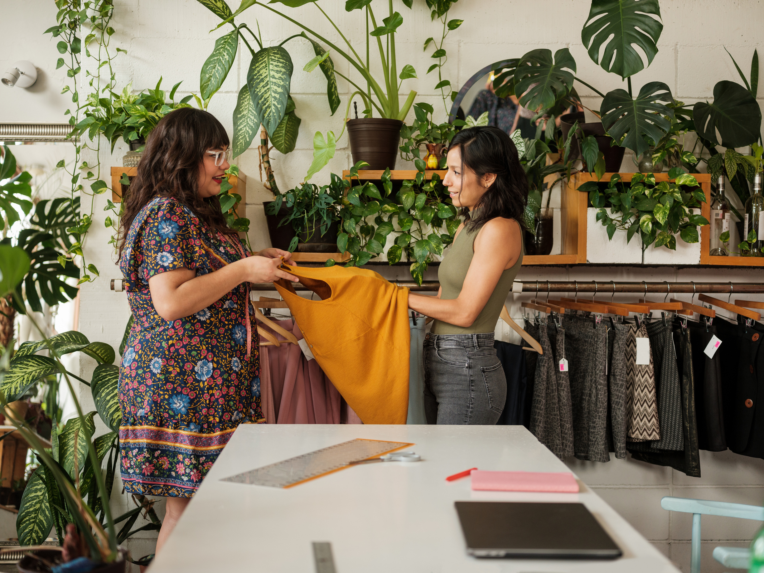 Latin customer touching fabric in eco-friendly clothes shop